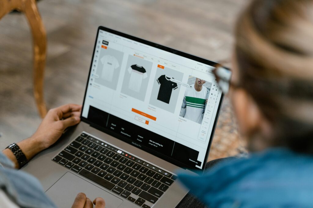 E-commerce Design service Two people collaborating on a laptop for t-shirt design and selection.